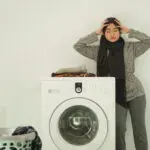 Asian woman wearing hijab stresses a lot of laundry at home