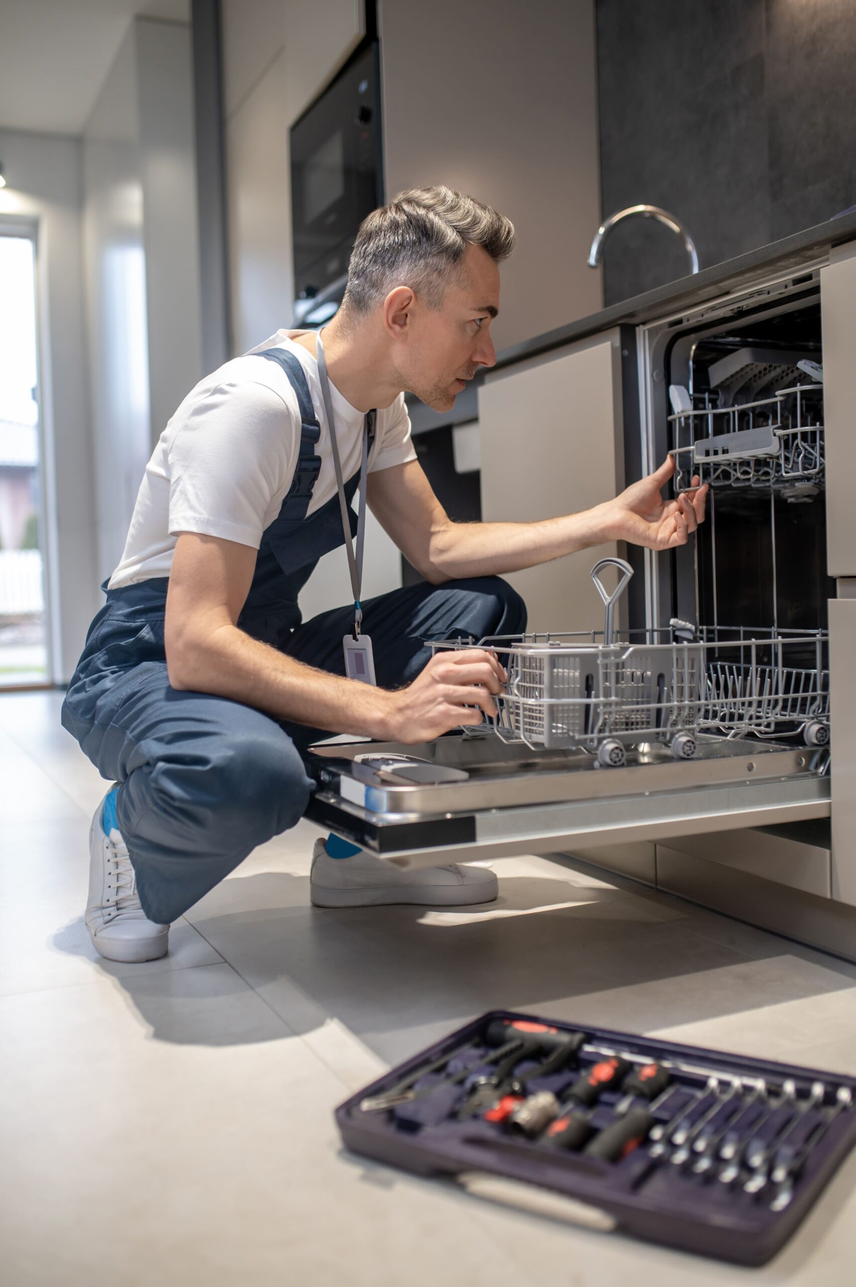 appliance repair technician repairing a dishwasher